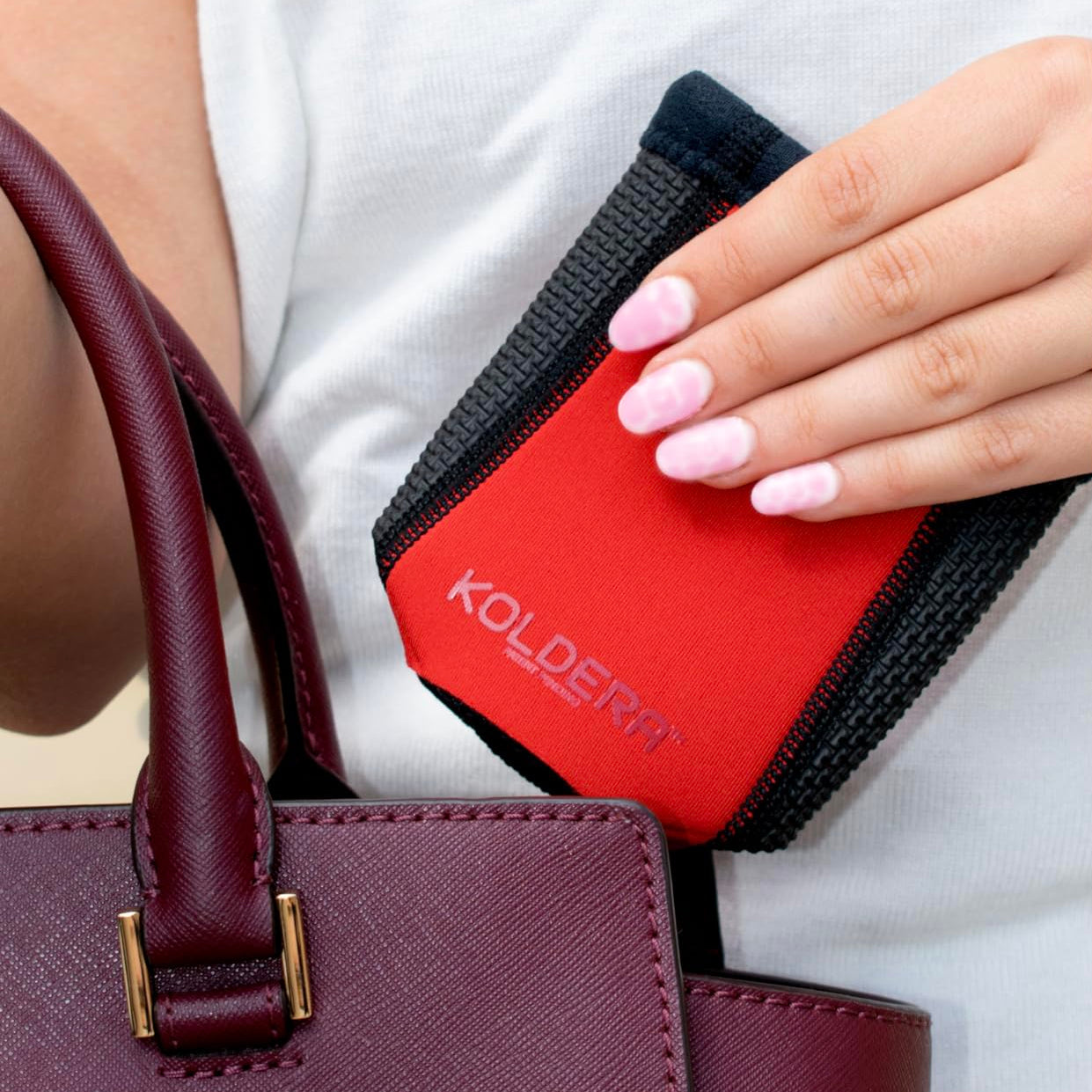 Red Kooleyo being placed into a purse with FoldFLAT Technology